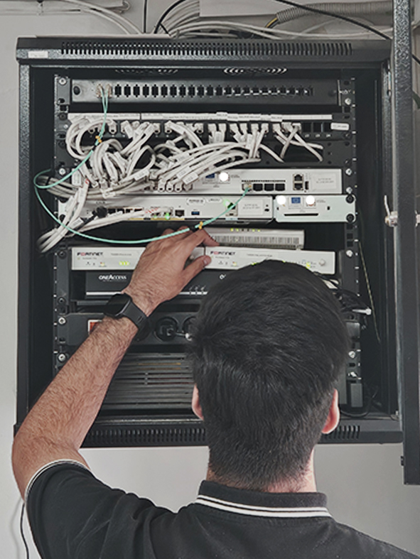 Técnico de Jovinet Informática realizando la instalación y mantenimiento de un armario RACK de telecomunicaciones en Chiclana, Cádiz